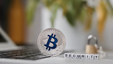 Digital currency physical metal bitcoin coin on the keyboard. Bitcoin security.
