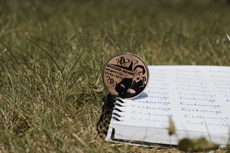 Digital currency physical metal bitcoin coin on the notebook with exchange inscription. Money outdoor concept.の写真素材