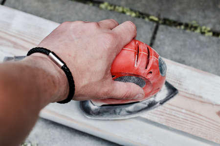 Home DIY concept. White man hand with bracelet reaching out the wood.の写真素材