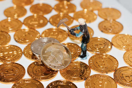 Digital currency physical metal bitcoin coin. Man mining bitcoins. Gold coins.の写真素材