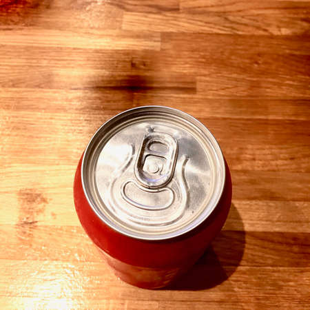 Small red can with drink on the wooden table. Drink concept.の写真素材