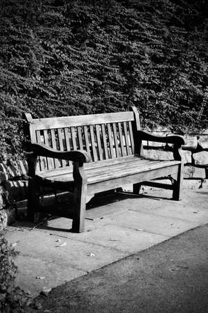 Old wooden bench in park near plants and stones. Richmond, Londonの写真素材