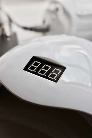 Cosmetics spa salon. White new nails uv lamp with electronic counter on the front.の写真素材