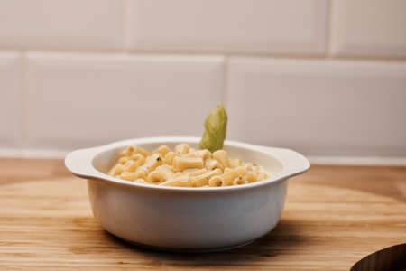 Delicious and fresh pasta on white plate on wooden board in the kitchen. Cooking concept.の写真素材