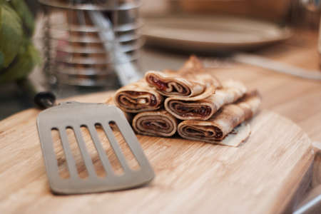 Delicious and fresh pancakes with strawberry sauce on the wooden board in the kitchen.の写真素材