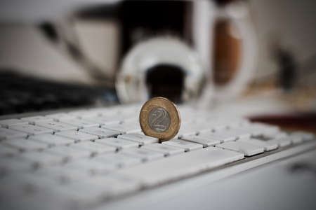 Physical coin polish money on the white computer keyboard.の写真素材