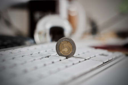 Physical coin polish money on the white computer keyboard.の写真素材