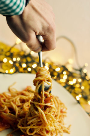 Italian tasty pasta with tomatoes on a fork. Christmas food concept.の写真素材