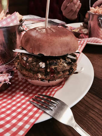 Big, fresh and delicious vegetable burger in restaurant on the white plate.の写真素材