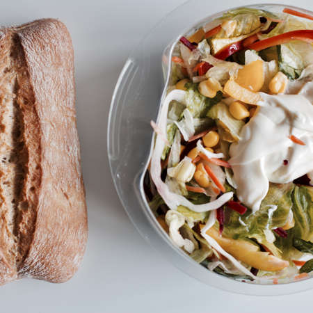 Eat near computer keyboard. Delicious fresh salad with mayo.の写真素材