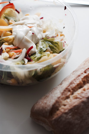 Eat near computer keyboard. Delicious fresh salad with mayo.の写真素材