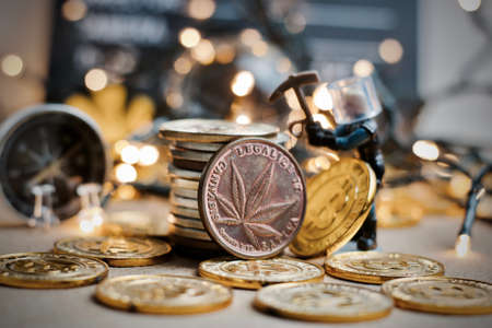 Physical brass marijuana coin with cannabis leaf on the front. Marijuana mining concept.の写真素材