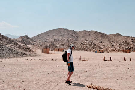 Young white man on the desert in Egypt. Sunny day and stones mountains.の写真素材