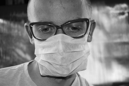 A young doctor wearing a mask and glasses. Medical photo concept.の写真素材