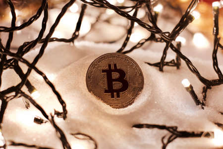 Digital currency physical metal bitcoin coin. Crypto currency christmas snow composition.の写真素材