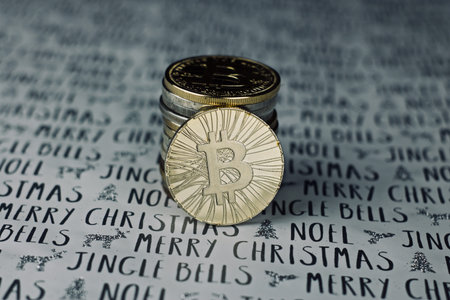 Digital currency physical metal bitcoin coin in christmas concept. White and grey background.