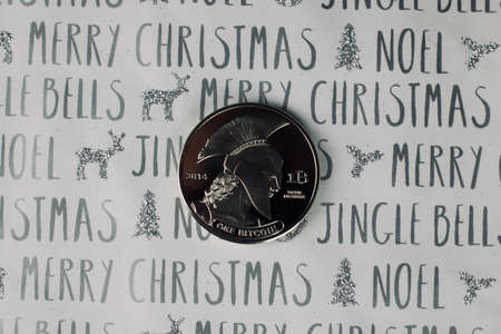 Digital currency physical metal bitcoin coin in christmas concept. White and grey background.の写真素材