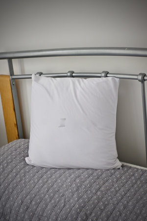 White small pillow on the bed in bedroom. White pillow mockup.の写真素材