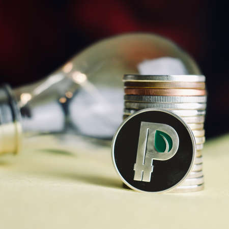 Digital currency physical metal silver peercoin coin with green leaf.の写真素材