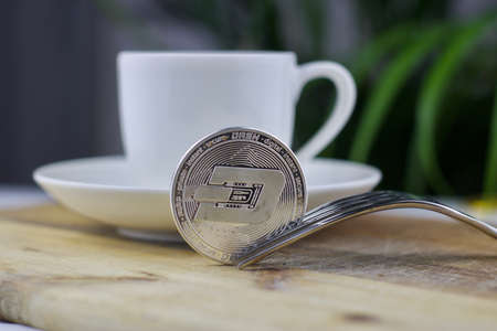 Digital currency physical metal silver dashcoin. Cryptocurrency coffee concept.の写真素材