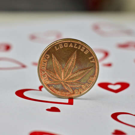Brass physical marijuana coin in love hearts scene.の写真素材
