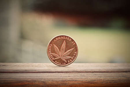Physical metal brass marijuana coin. Cannabis coin concept.の写真素材