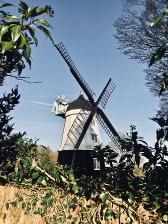 Old black and white wind mill on the farm. Countryside green concept.の写真素材