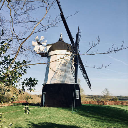 Old black and white wind mill on the farm. Countryside green concept.の写真素材