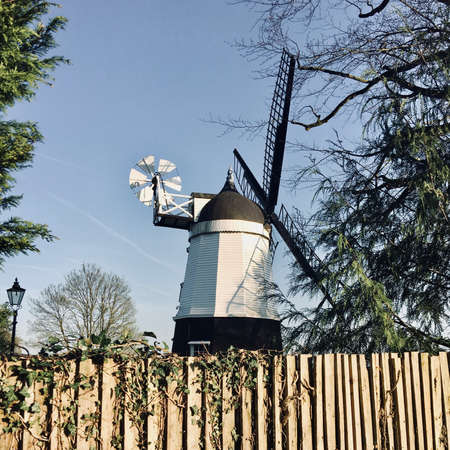 Old black and white wind mill on the farm. Countryside green concept.の写真素材