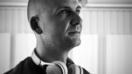 Young bald men in white headphones. Music concept.の写真素材