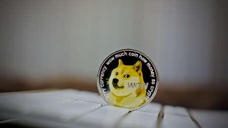 Digital currency physical metal dogecoin coin on white computer keyboaed.の写真素材