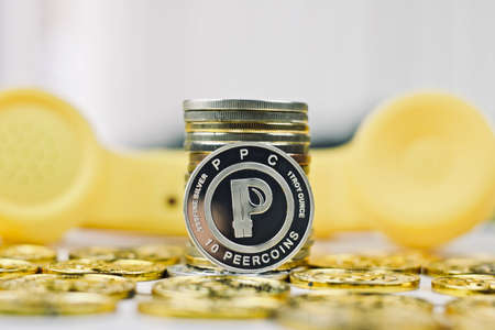 Digital currency physical metal silver coin near yellow phone.の写真素材