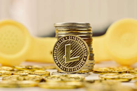 Digital currency physical metal litecoin coin. Yellow phone concept.の写真素材