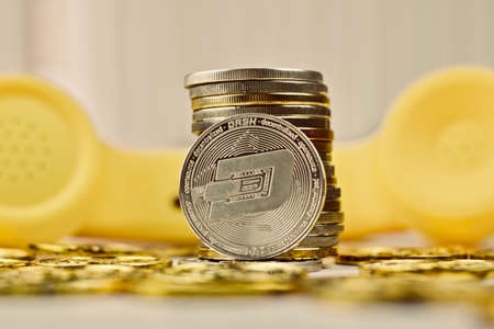 Digital currency physical metal silver dashcoin coin. Yellow phone communication concept.の写真素材