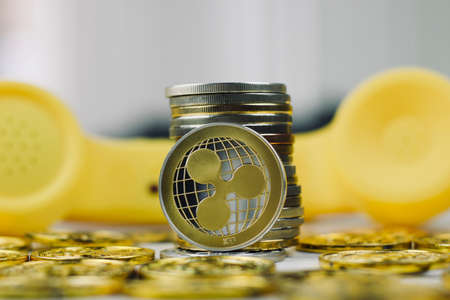 Digital currency physical metal ripple coin. Yellow phone communication concept.の写真素材