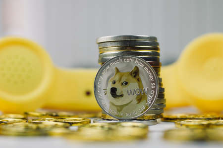 Digital currency physical metal dogecoin coin. Yellow phone communication concept.の写真素材