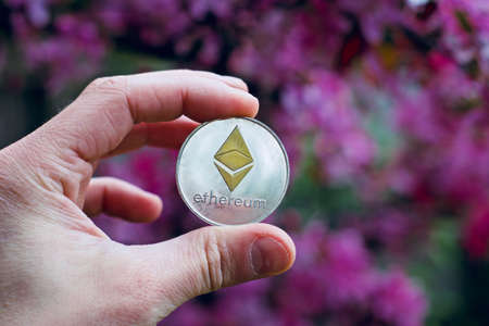 Digital currency physical metal silver ethereum coin. Cryptocurrency outdoor concept.の写真素材
