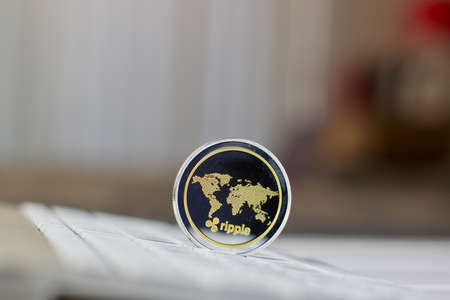 Digital currency physical metal ripple coin on the white computer keyboard.の写真素材