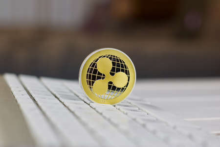 Digital currency physical metal ripple coin on the white computer keyboard.の写真素材