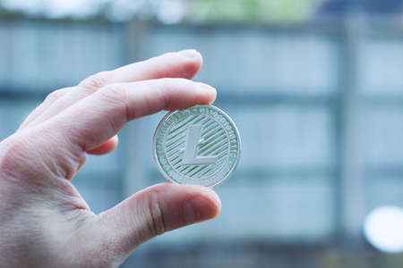 Digital currency physical metal silver litecoin coin. Cryptocurrency outdoor concept.の写真素材