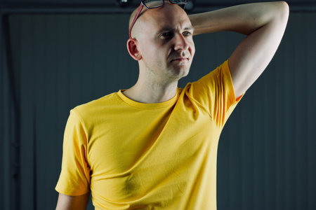 Bald young man in yellow tshirt. Tshirt mockup concept.