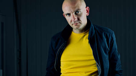 Bald young man in yellow tshirt. Tshirt mockup concept.の写真素材