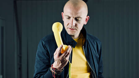 Bald young man in yellow tshirt. Tshirt mockup concept.の写真素材