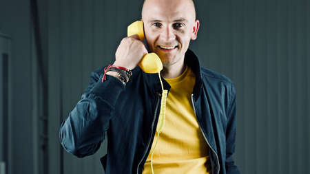 Bald young man in yellow tshirt. Tshirt mockup concept.の写真素材
