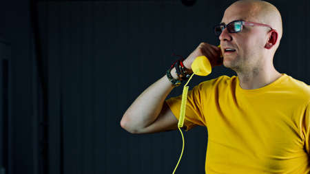 Bald young man in yellow tshirt. Tshirt mockup concept.の写真素材