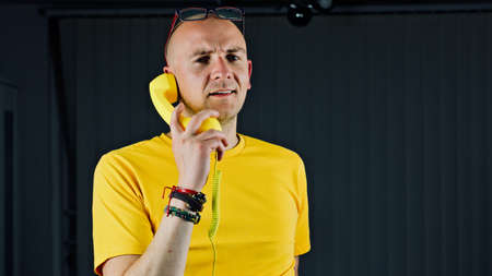 Bald young man in yellow tshirt. Tshirt mockup concept.の写真素材