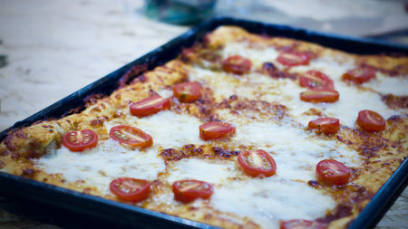 Fresh and tasty vegetarian homemade pizza with tomatoes and rucola.