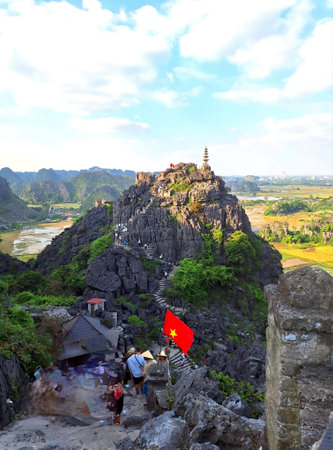 Unidentified people visit the top of the mountain with a red flag in Hua Hin, Vietnam.の写真素材