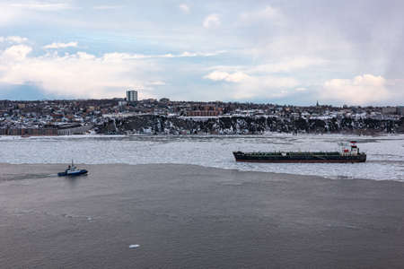 Quebec city, Quebec, Canada - March 14, 2021: At the sunset, winter view of the maritime traffic on the St. Lawrence river in front of Quebec city.のeditorial素材