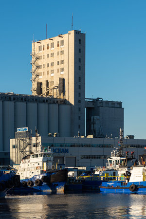 Quebec city, Quebec, Canada - April 24, 2020: Tugs in the harbor of Quebec with industrial grain elevator in background.のeditorial素材